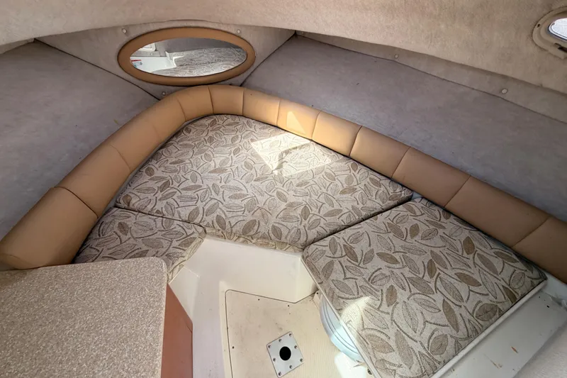 Slide: The Image of 2008 Robalo R225 Walkaround cabin interior with patterned cushions and round mirror. - 20