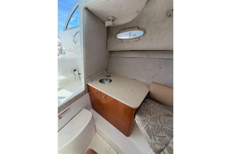 Slide: The Image of 2008 Robalo R225 Walkaround cabin interior with sink and seating area. - 21