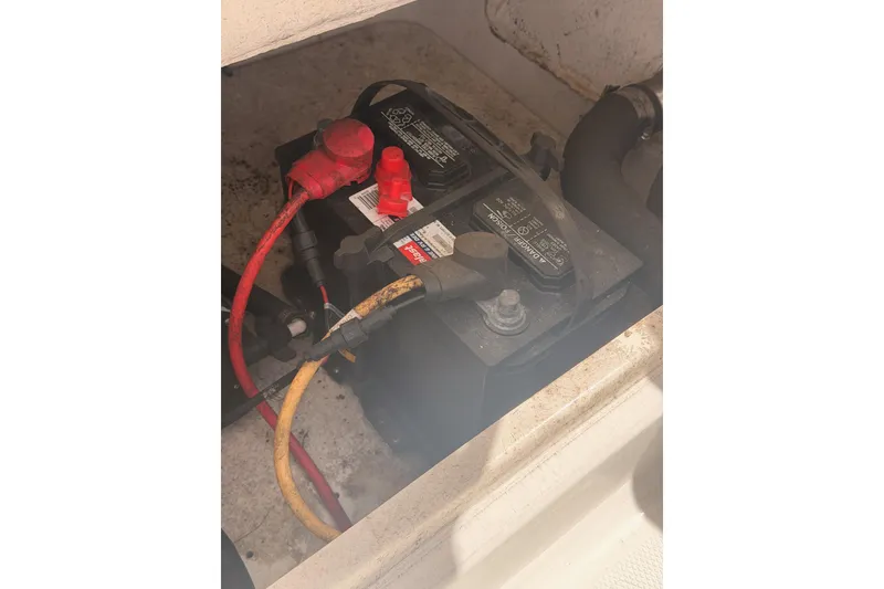 Slide: The Image of Battery compartment of 2008 Robalo R225 Walkaround boat with connected cables. - 28