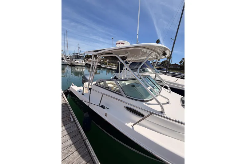 Slide: The Image of 2008 Robalo R225 Walkaround boat docked in marina under clear blue sky. - 3