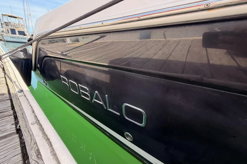Slide: The Image of 2008 Robalo R225 Walkaround boat docked, showcasing sleek black hull design. - 5