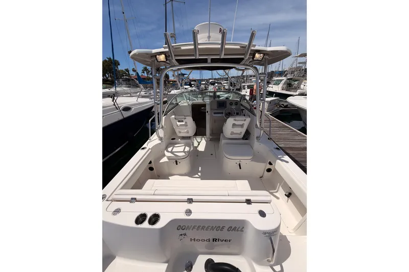 Slide: The Image of 2008 Robalo R225 Walkaround boat docked, featuring spacious cockpit and helm area. - 7