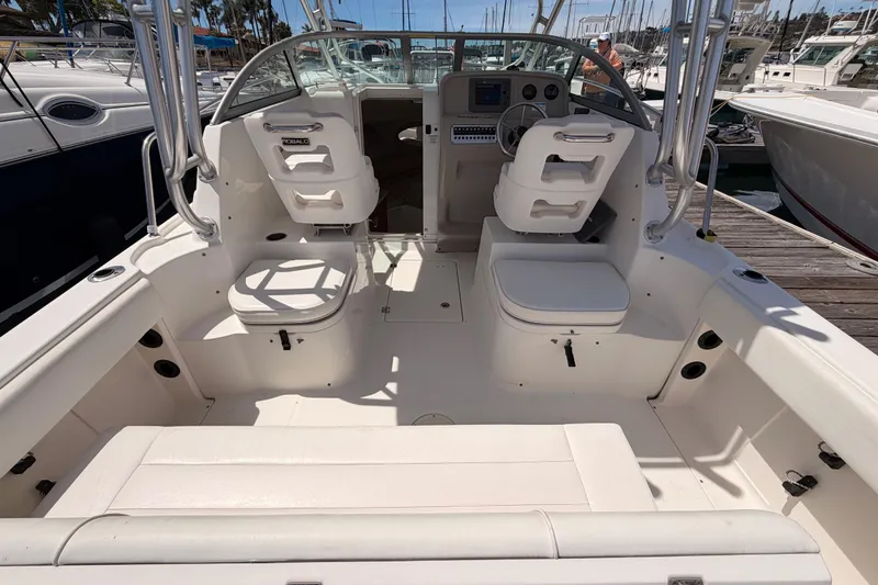Slide: The Image of 2008 Robalo R225 Walkaround boat interior with seating and control panel at marina. - 8