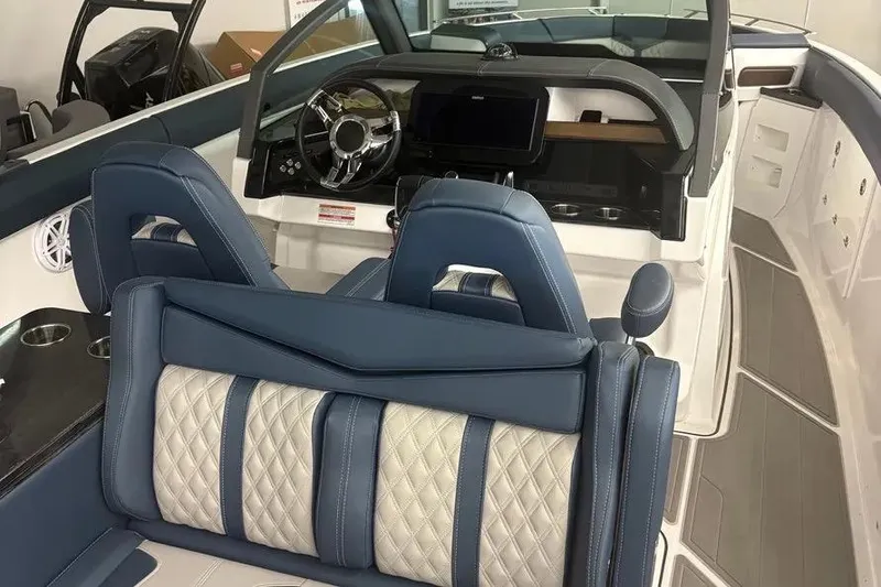 Slide: The Image of Luxurious interior of 2025 Monterey Elite 30 OB boat with blue and white seating. - 10