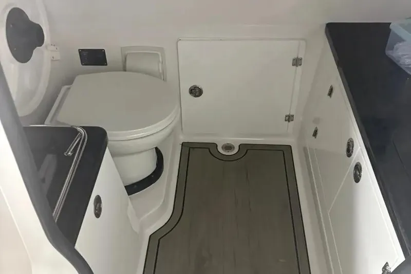Slide: The Image of 2025 Monterey Elite 30 OB boat bathroom interior with toilet and cabinetry. - 7
