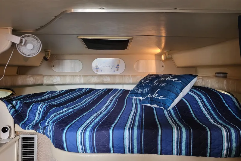 Slide: The Image of Cozy cabin interior of 1999 Rinker Fiesta Vee 330 with striped bedding and decorative pillow. - 10