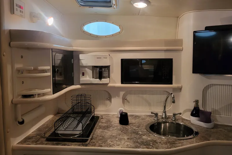 Slide: The Image of 1999 Rinker Fiesta Vee 330 boat kitchen with sink, microwave, and coffee maker. - 15