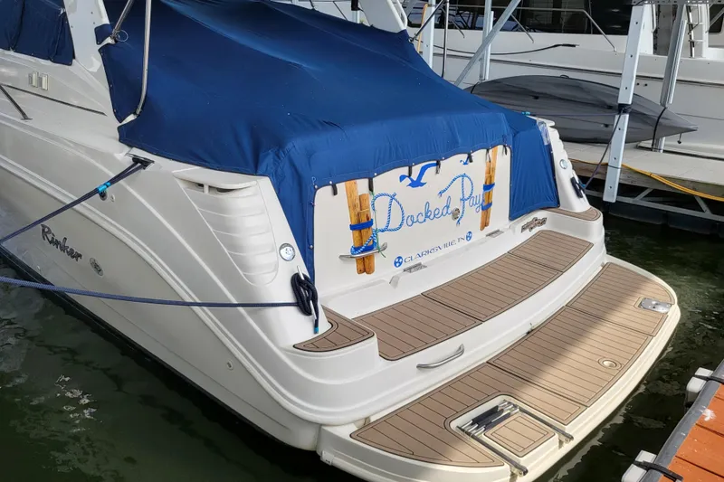 Slide: The Image of 1999 Rinker Fiesta Vee 330 boat docked with blue cover and wooden deck. - 3