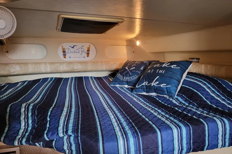 Slide: The Image of Cozy cabin interior of 1999 Rinker Fiesta Vee 330 with striped bedding and decorative pillows. - 7