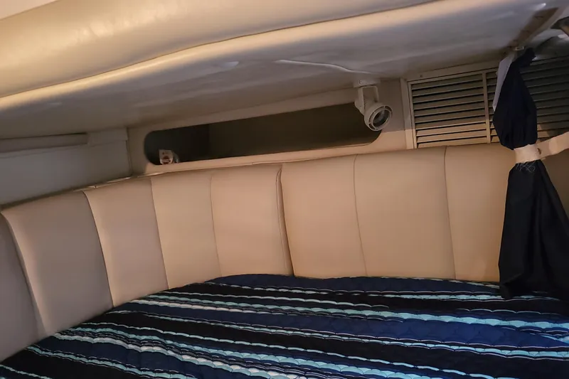 Slide: The Image of Interior cabin of 1999 Rinker Fiesta Vee 330 with striped bedding. - 8