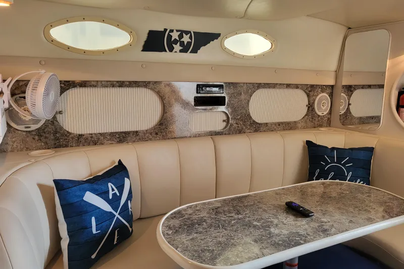 Slide: The Image of Interior of a 1999 Rinker Fiesta Vee 330 boat with beige seating and decorative pillows. - 9