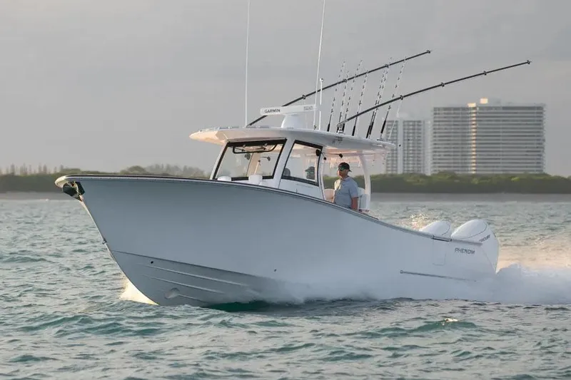 The Image of Manufacturer Provided Image: 2025 Phenom 37 boat cruising on water with fishing rods, cityscape in background. - 0