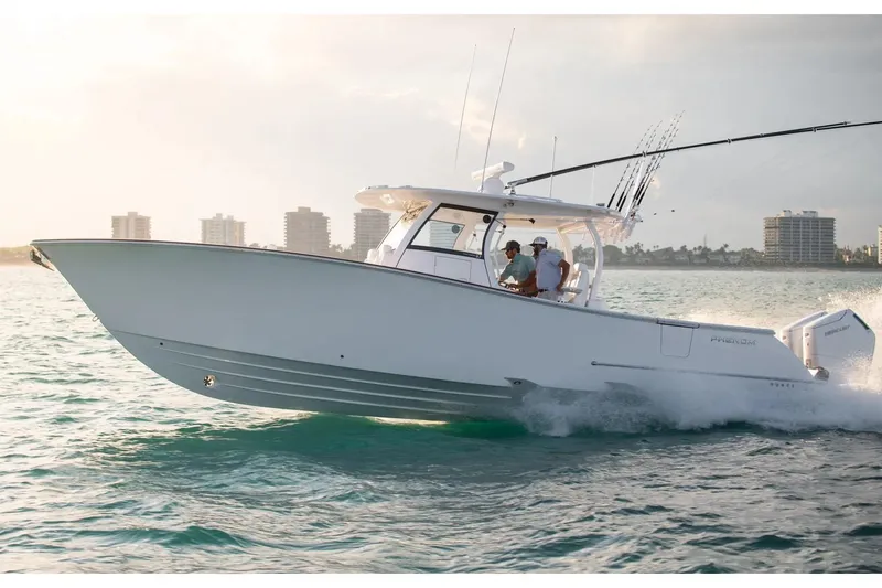 Slide: The Image of Manufacturer Provided Image: Phenom 37 boat cruising on water, 2025 model, with city skyline in background. - 2