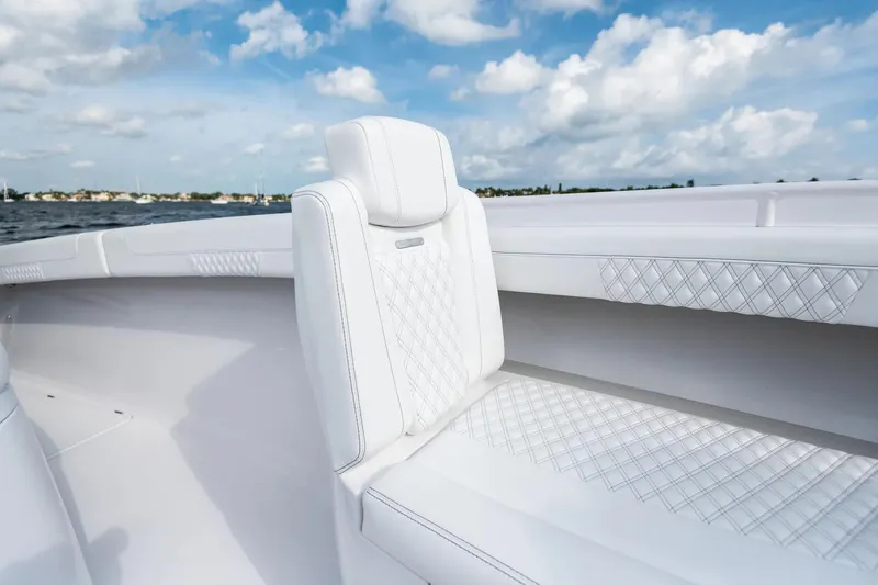 Slide: The Image of Manufacturer Provided Image: Luxurious seating on 2025 Phenom 37 boat with quilted upholstery and ocean backdrop. - 7
