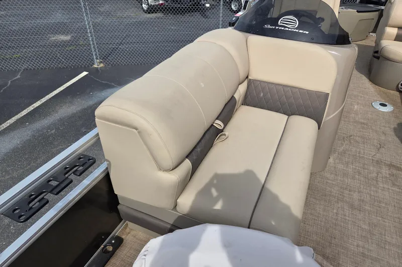Slide: The Image of 2023 Sun Tracker Fishin' Barge 20 DLX boat interior with beige seating and steering console. - 8