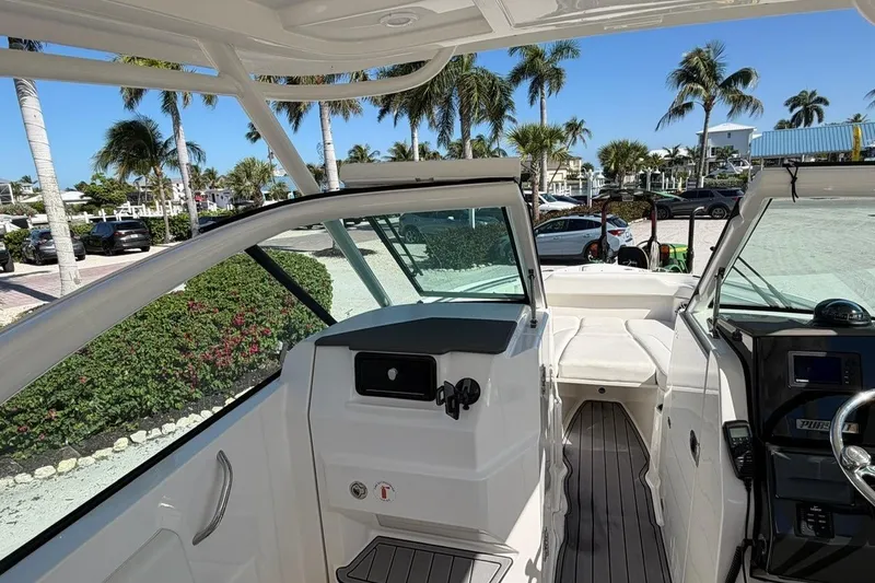 Slide: The Image of 2021 Pursuit DC 266 Dual Console boat interior with palm trees in the background. - 11