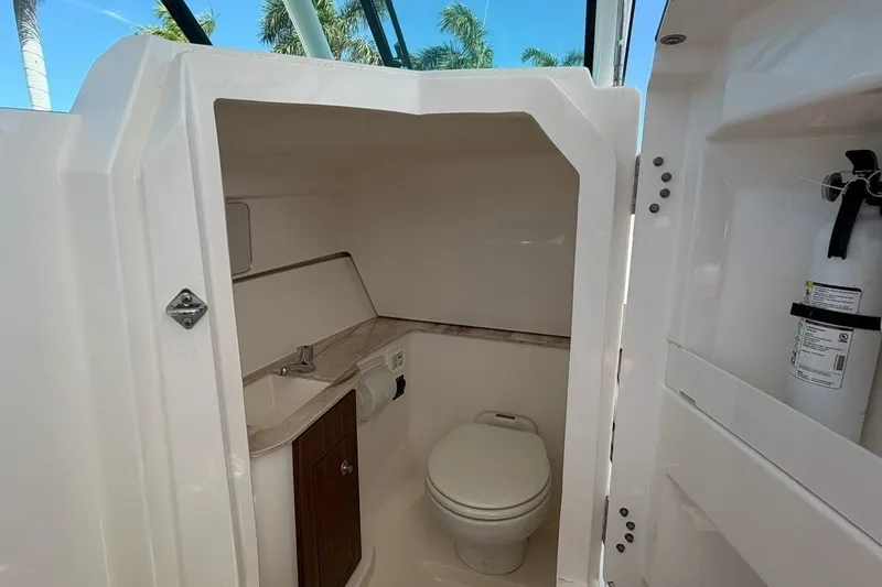 Slide: The Image of 2021 Pursuit DC 266 Dual Console boat interior with toilet and sink. - 13