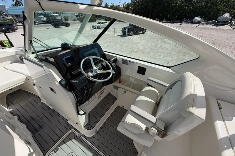 Slide: The Image of 2021 Pursuit DC 266 Dual Console boat interior with steering wheel and seating. - 14