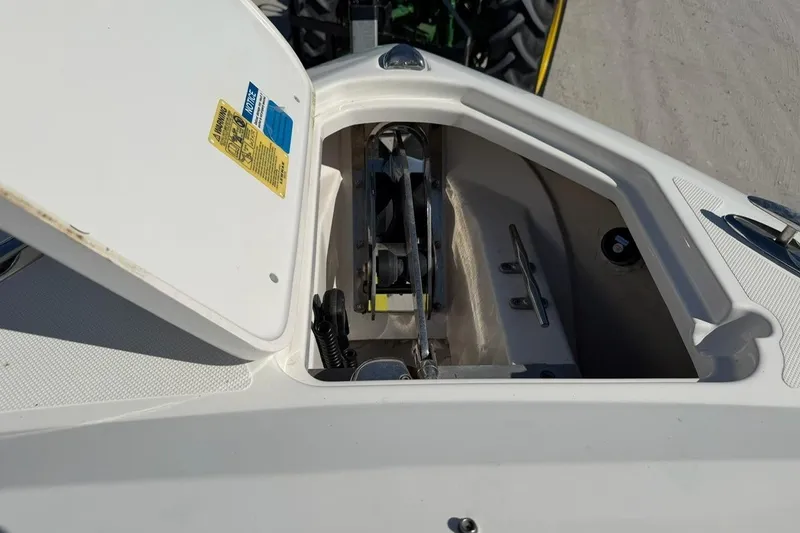 Slide: The Image of Open anchor locker on 2021 Pursuit DC 266 Dual Console boat, showing anchor mechanism. - 18