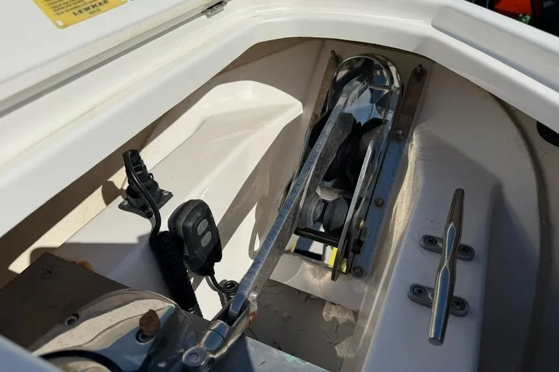 Slide: The Image of Anchor compartment of 2021 Pursuit DC 266 Dual Console boat, featuring cleat and equipment. - 19