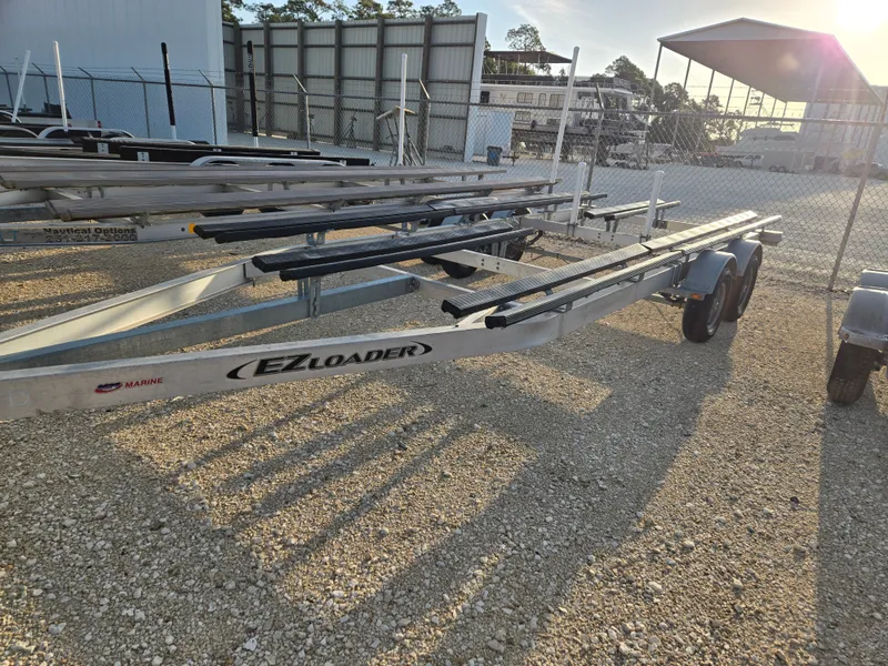 Slide: The Image of EZ Loader boat trailer on gravel lot, Bennington 22SVSRST 2022. - 10