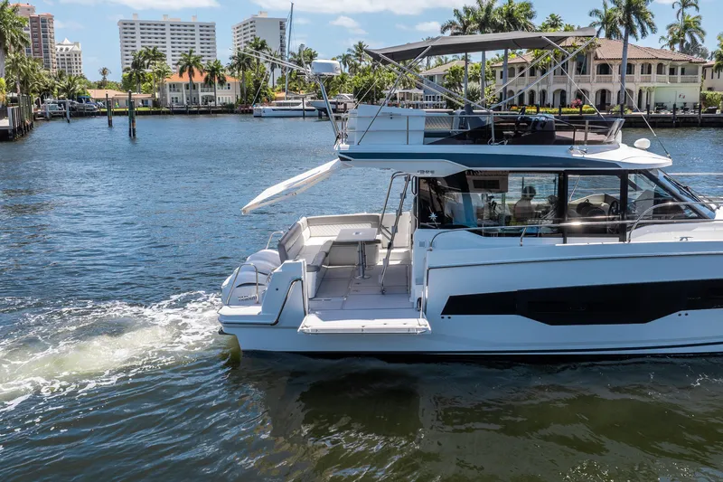 Slide: The Image of 2024 Jeanneau NC 1295 Fly yacht cruising on a sunny waterfront. - 12