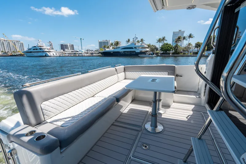 Slide: The Image of 2024 Jeanneau NC 1295 Fly yacht deck with seating and table, docked in marina. - 20