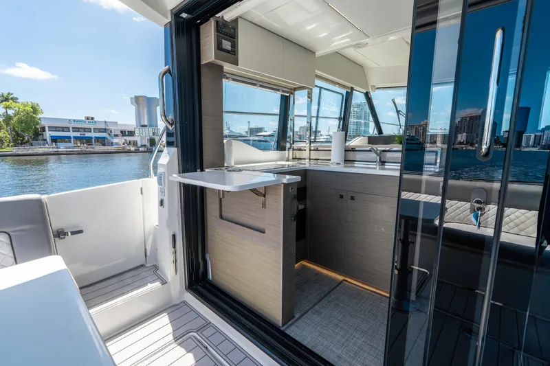 Slide: The Image of 2024 Jeanneau NC 1295 Fly yacht interior with modern kitchen and waterfront view. - 21