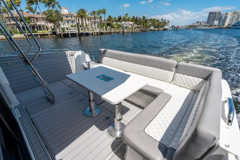 Slide: The Image of 2024 Jeanneau NC 1295 Fly yacht deck with seating and table, cruising on a sunny day. - 22