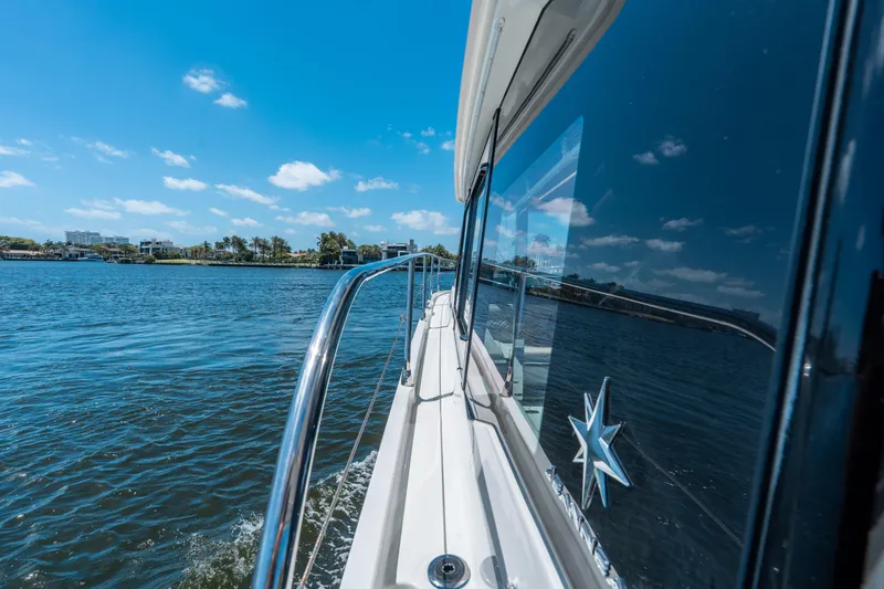 Slide: The Image of 2024 Jeanneau NC 1295 Fly cruising on a sunny day, reflecting blue skies and water. - 26