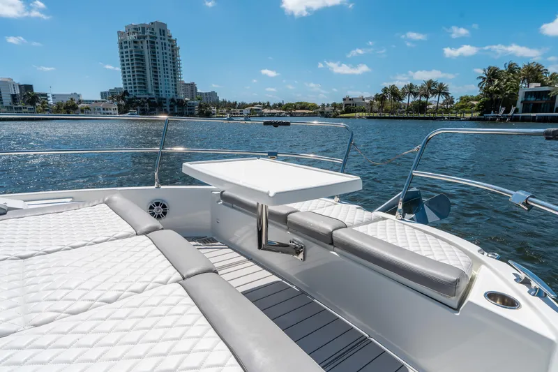Slide: The Image of 2024 Jeanneau NC 1295 Fly yacht deck with seating, table, and waterfront view. - 29