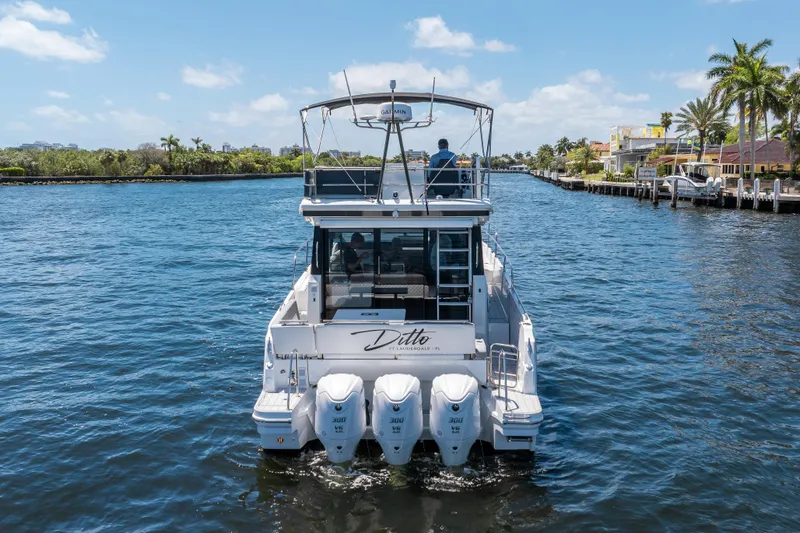 Slide: The Image of 2024 Jeanneau NC 1295 Fly cruising on a sunny waterway with palm trees. - 3