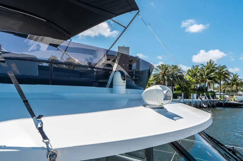 Slide: The Image of 2024 Jeanneau NC 1295 Fly yacht with sleek design, docked near palm trees. - 32