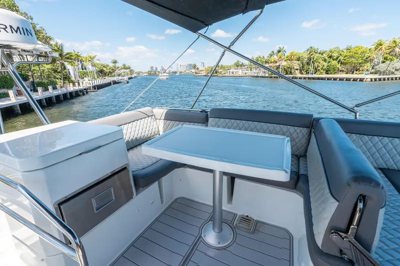 Slide: The Image of 2024 Jeanneau NC 1295 Fly yacht interior with seating and table, overlooking scenic waterway. - 36