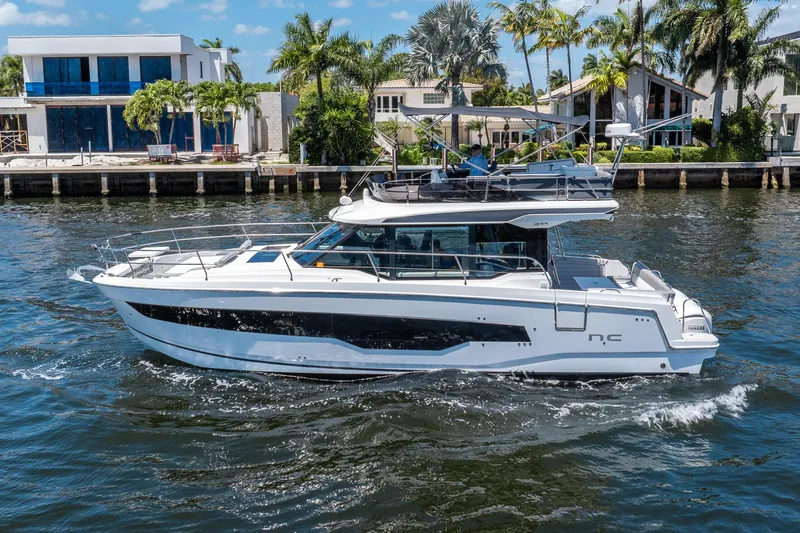 Slide: The Image of 2024 Jeanneau NC 1295 Fly on water near modern homes. - 37