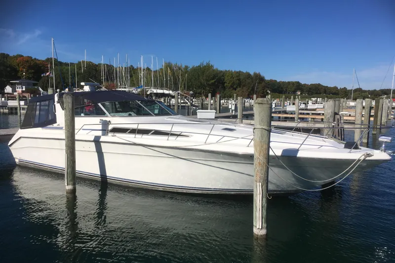 The Image of 1989 Sea Ray 420 Sundancer yacht docked in a marina under clear blue skies. - 0