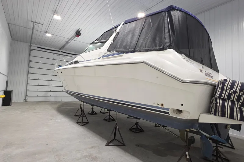Slide: The Image of 1989 Sea Ray 420 Sundancer yacht stored indoors on stands. - 11