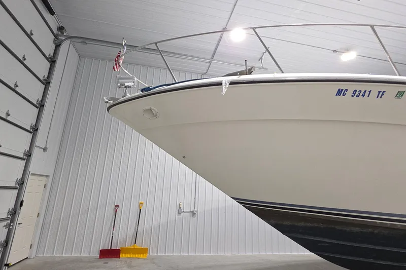 Slide: The Image of 1989 Sea Ray 420 Sundancer boat stored indoors, with visible registration number. - 13