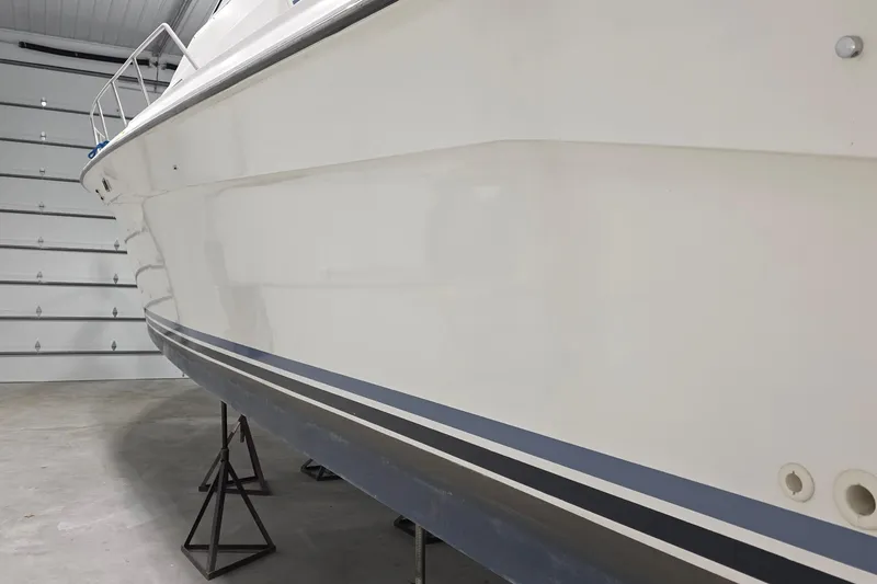 Slide: The Image of 1989 Sea Ray 420 Sundancer boat in storage, side view showing hull and railings. - 14