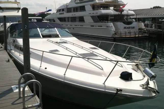 Slide: The Image of 1989 Sea Ray 420 Sundancer docked at marina, sleek design, luxury yacht. - 2