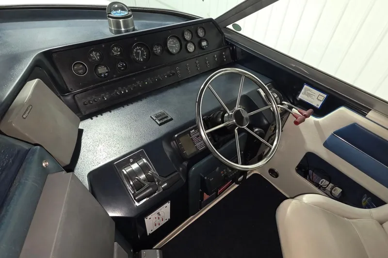 Slide: The Image of 1989 Sea Ray 420 Sundancer helm with steering wheel and control panel. - 22