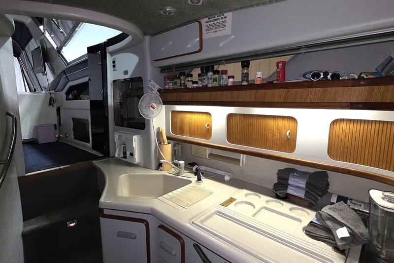 Slide: The Image of Interior of 1989 Sea Ray 420 Sundancer yacht with kitchenette and storage cabinets. - 25