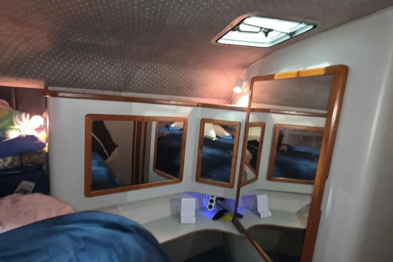 Slide: The Image of Interior cabin of 1989 Sea Ray 420 Sundancer with mirrors and cozy bedding. - 29