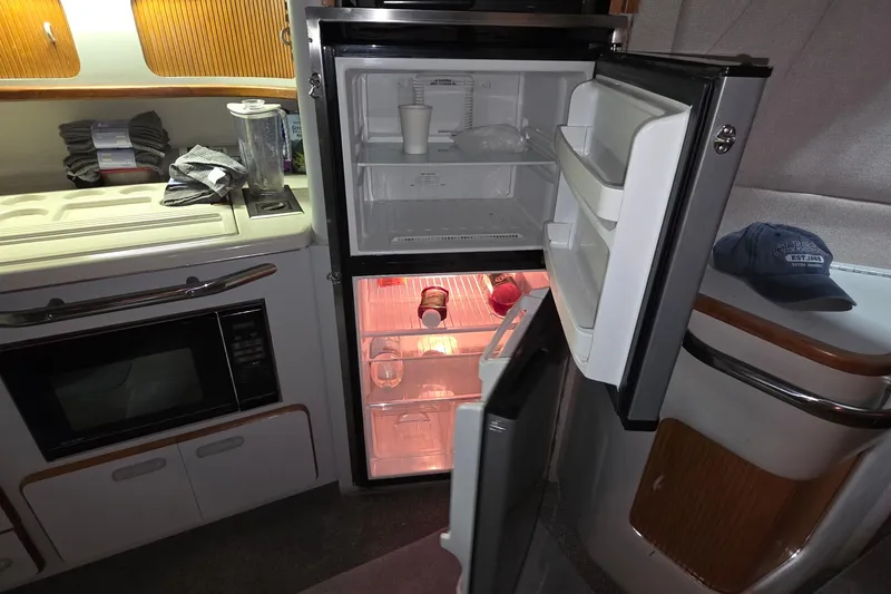 Slide: The Image of Kitchen area of 1989 Sea Ray 420 Sundancer with open fridge and microwave. - 33