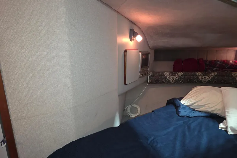 Slide: The Image of Cozy cabin interior of 1989 Sea Ray 420 Sundancer with bed and small TV. - 34