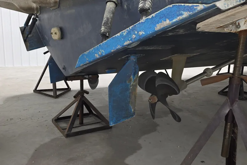 Slide: The Image of 1989 Sea Ray 420 Sundancer boat hull and propeller on stands in a garage. - 35