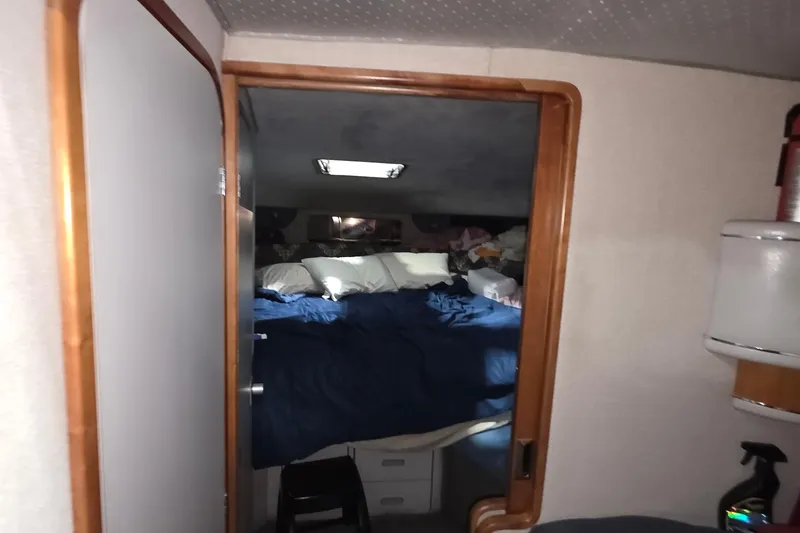 Slide: The Image of Interior cabin of 1989 Sea Ray 420 Sundancer with cozy bedding and wooden accents. - 37