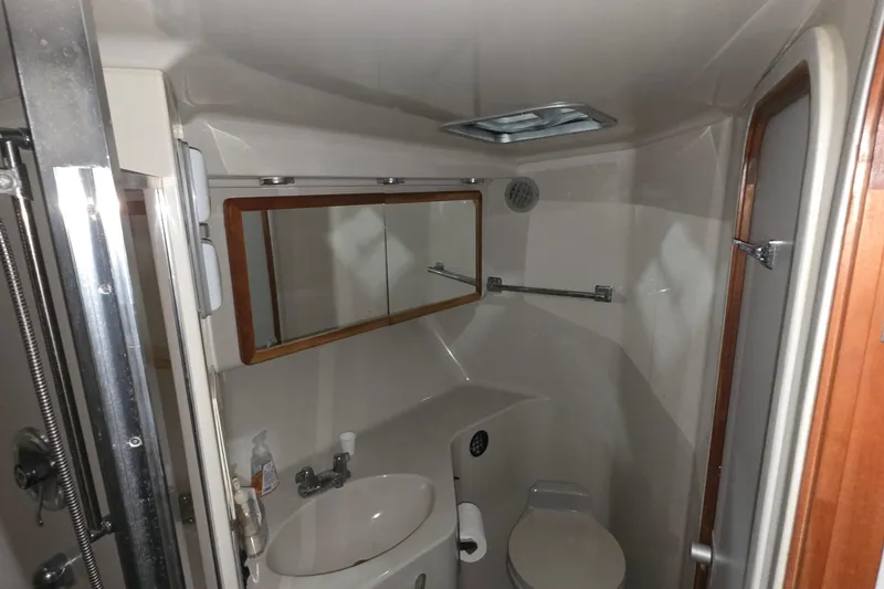 Slide: The Image of Bathroom interior of 1989 Sea Ray 420 Sundancer yacht, featuring sink, toilet, and mirror. - 38