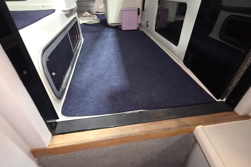 Slide: The Image of Interior view of 1989 Sea Ray 420 Sundancer with blue carpet and cabin windows. - 39