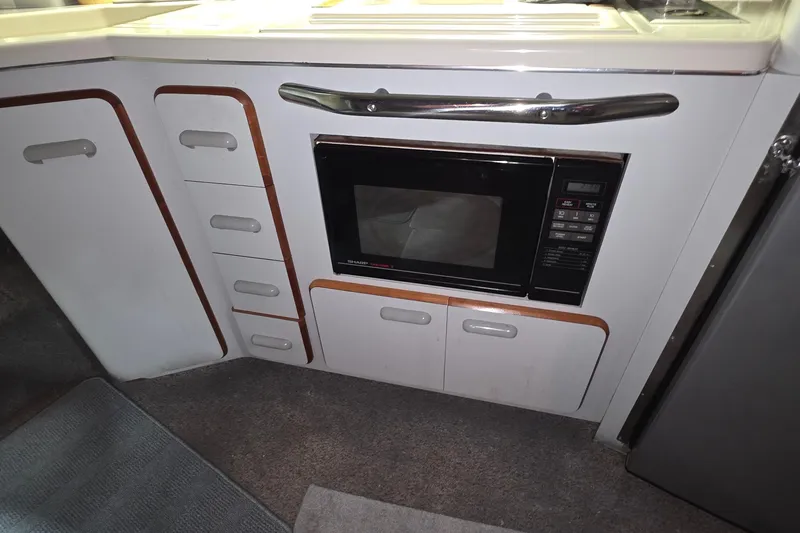 Slide: The Image of 1989 Sea Ray 420 Sundancer kitchen with microwave and storage cabinets. - 41